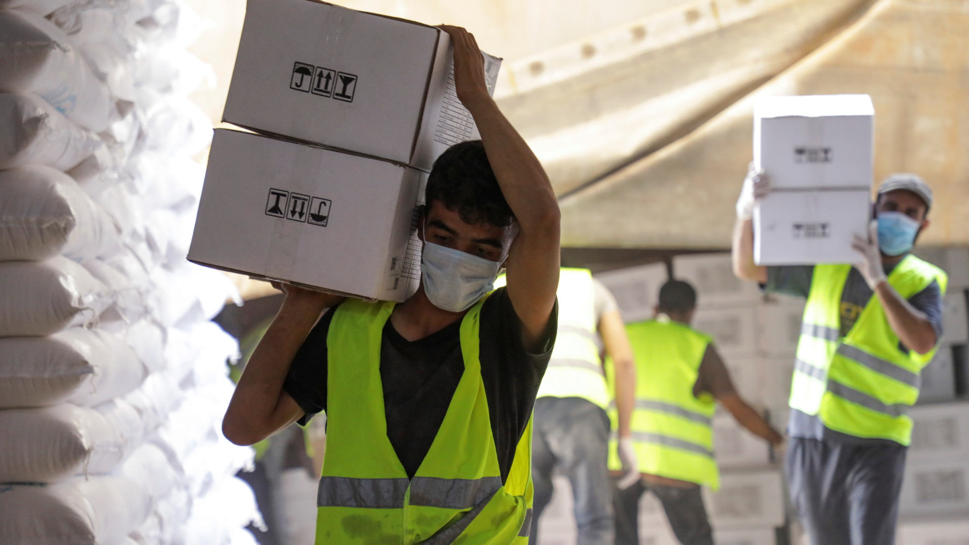 Arbeiter tragen Hilfsgüter für Syrien in der Nähe des Grenzübergangs Bab al-Hawa | REUTERS