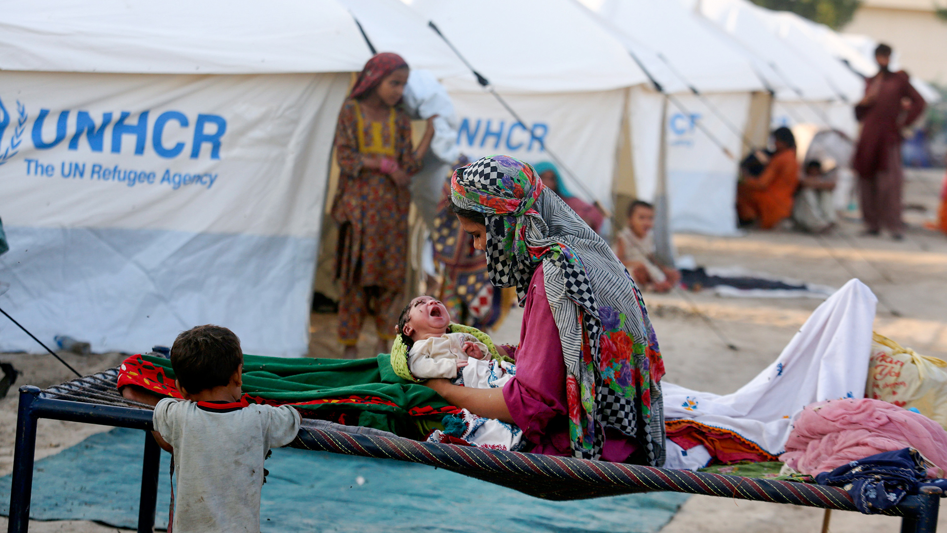 Eine vertriebene Frau hält ihr neugeborenes Baby im Arm, während sie in einem vom UN-Flüchtlingshilfswerk (UNHCR) organisierten provisorischen Zeltlager für Flutopfer in Sukkur, Pakistan, Zuflucht sucht. | AP