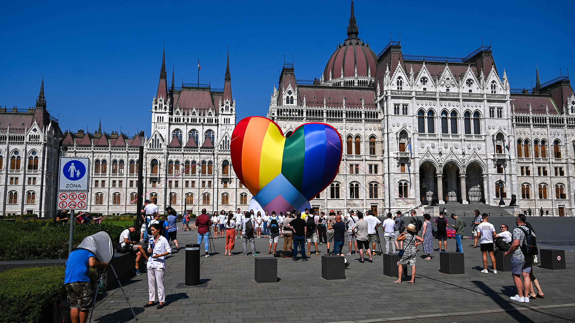 Aktivistinnen und Aktivisten gehen an einem großen regenbogenfarbenen Herz vorbei, das vor dem Parlamentsgebäude in Budapest aufgestellt wurde.  | AFP