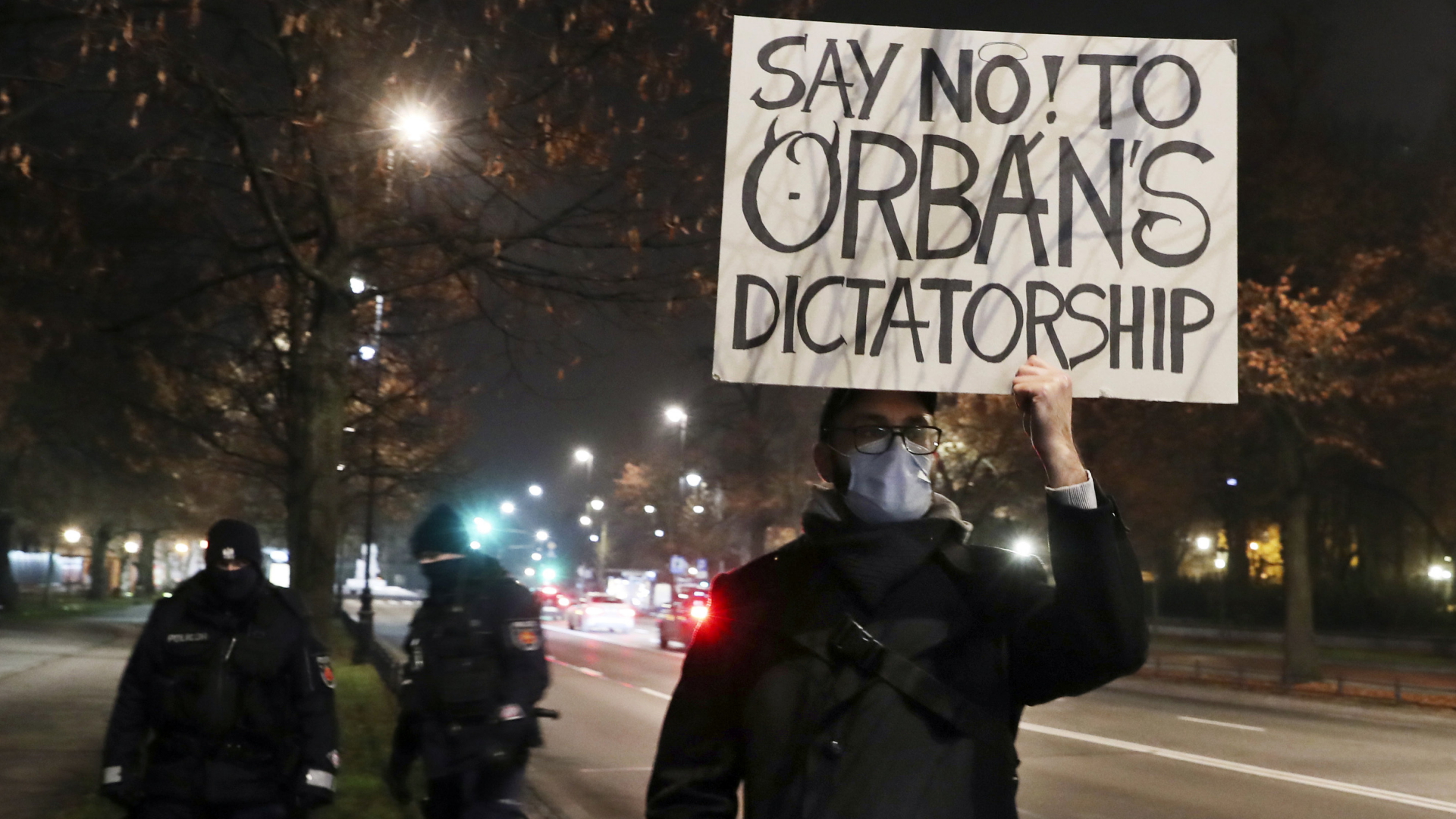 Ein Mann hält ein Plakat, in der Ungarns Premierminister Orban als Diktator bezeichnet wird. | AP