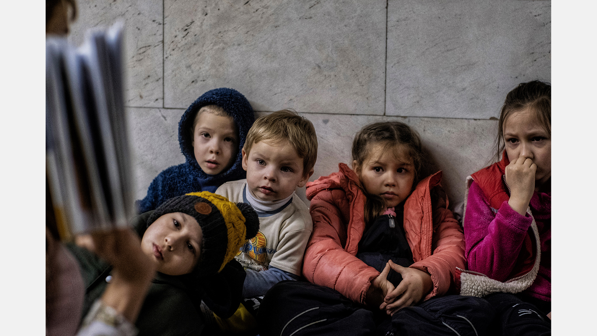 Eine Lehrerin liest einer Gruppe von Mädchen und Jungen in einem Souterrain der Hauptstadt Kiew Geschichten vor.