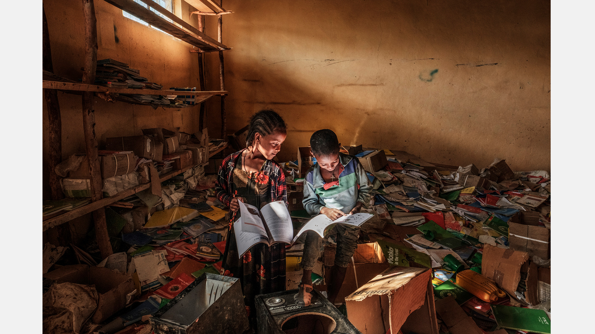 Zwei Kinder, die sich in der kriegszerstörten Bibliothek einer Grundschule in der äthiopischen Region Tigray in Bücher vertiefen.  | Eduardo Soteras, Argentinien, AFP (Agence France Press)