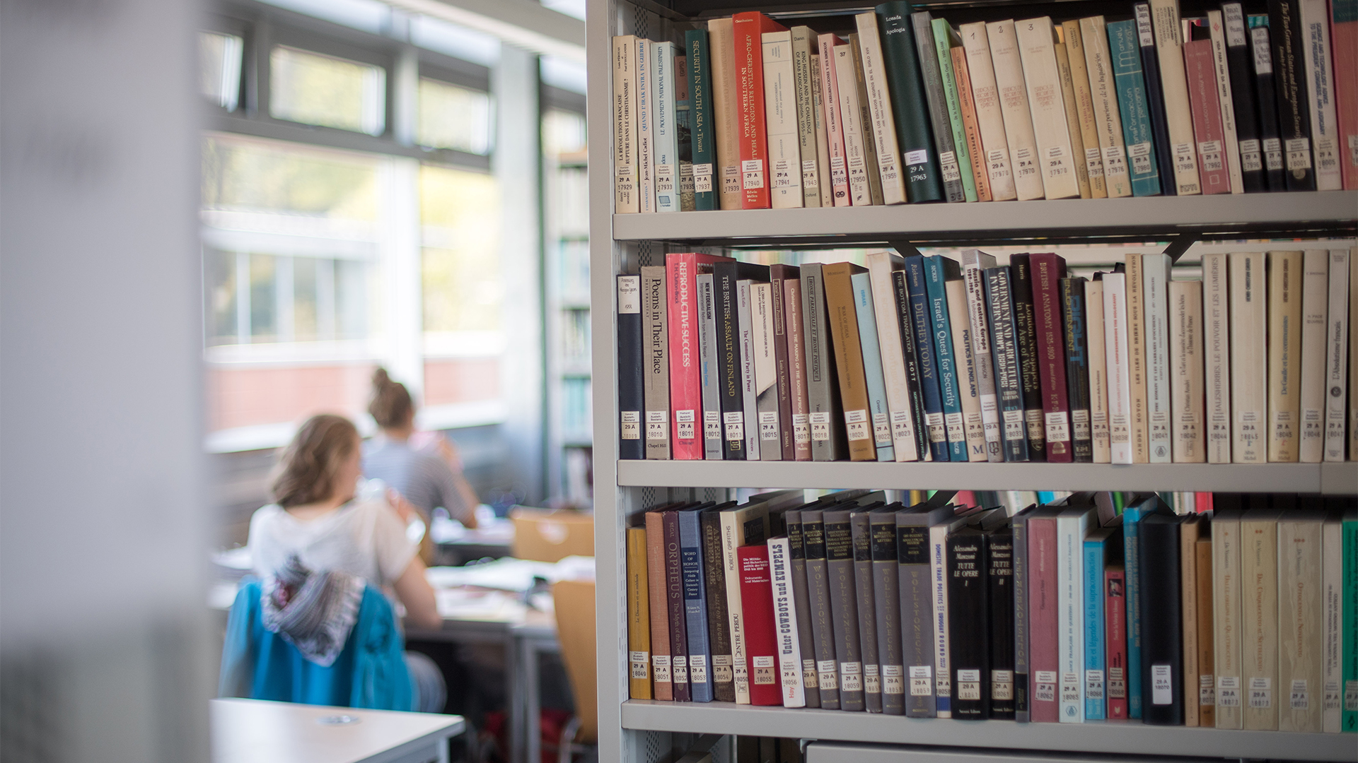 StudentInnen lernen in der Bibliothek neben Bücherregalen. | picture alliance/dpa