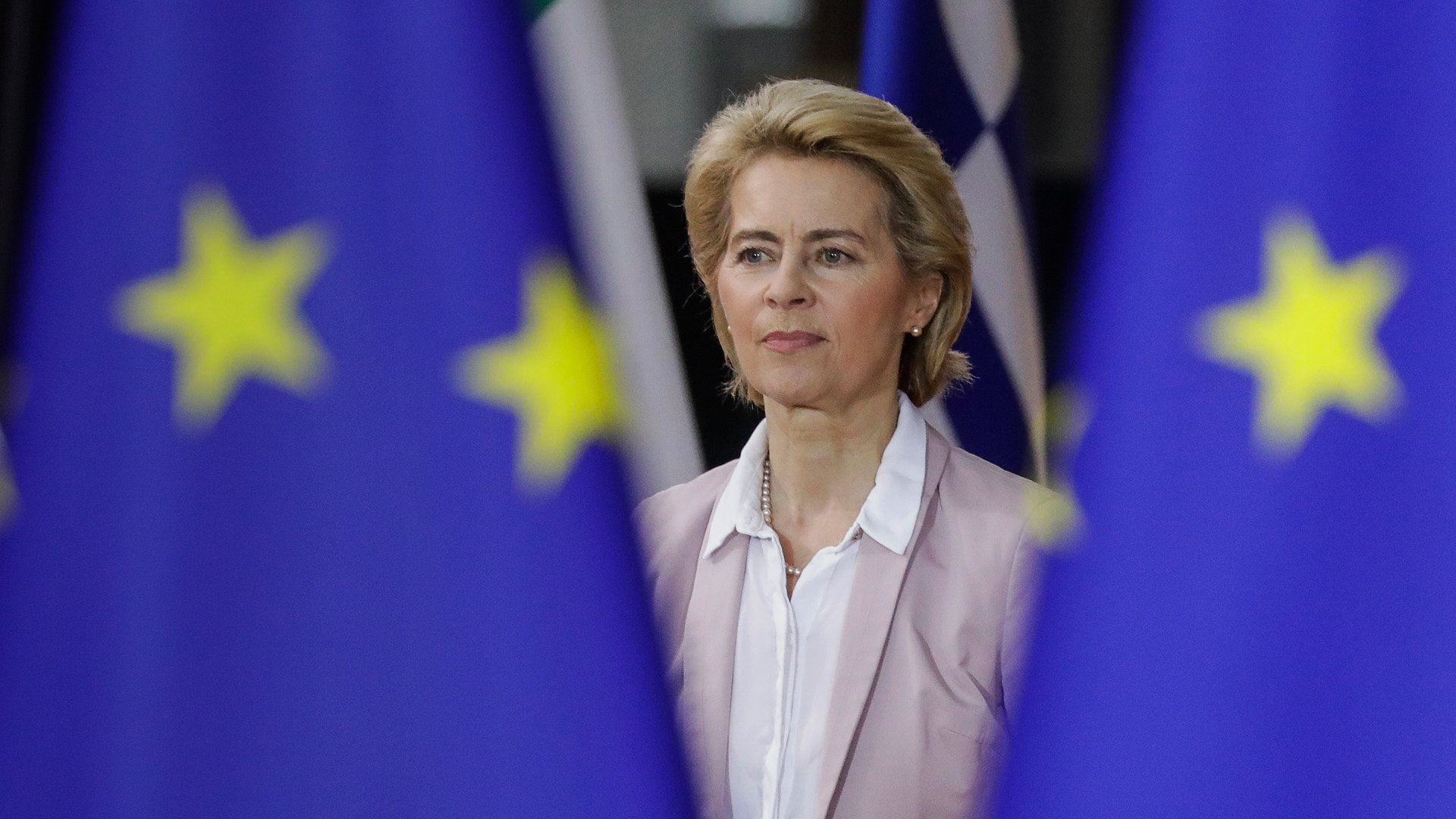 Ursula von der Leyen neben der Flagge der Europäischen Union | dpa