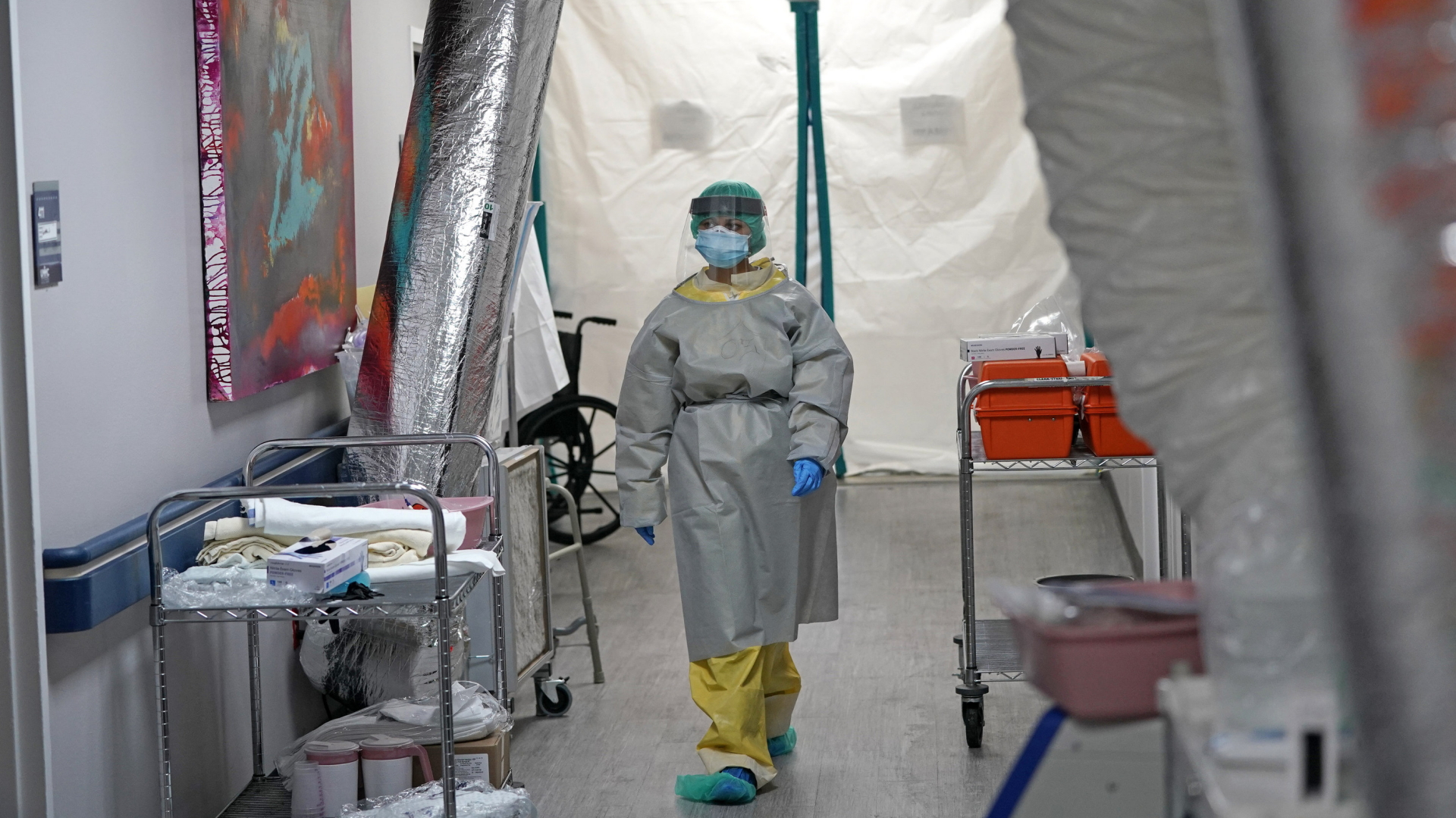 Eine Ärztin in Schutzkleidung geht über einen Krankenhausflur in Houston, Texas. | AP