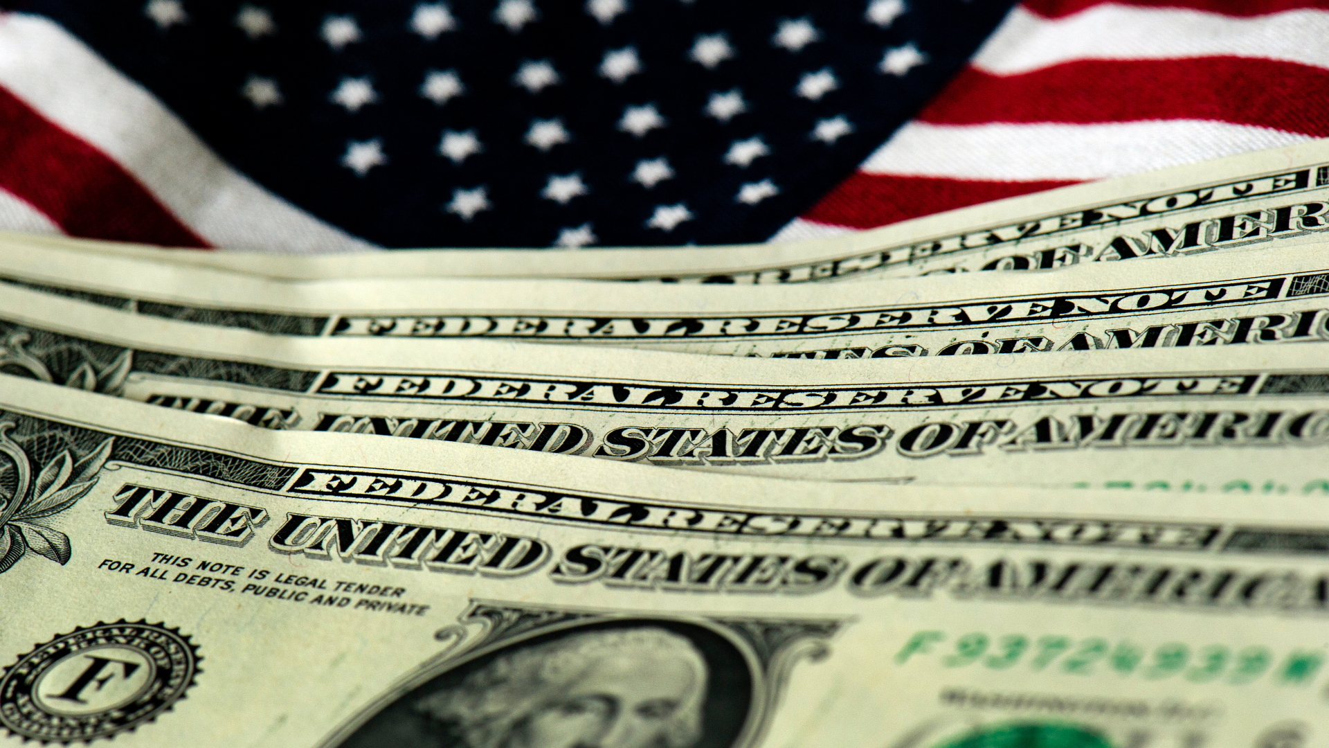 Dollar-Scheine vor einer US-Flagge | dpa