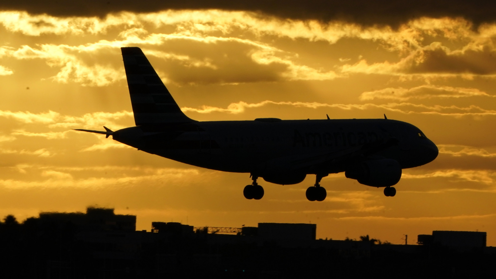 Ein Flugzeug im Landeanflug bei Sonnenuntergang auf den Miami International Airport. | AP
