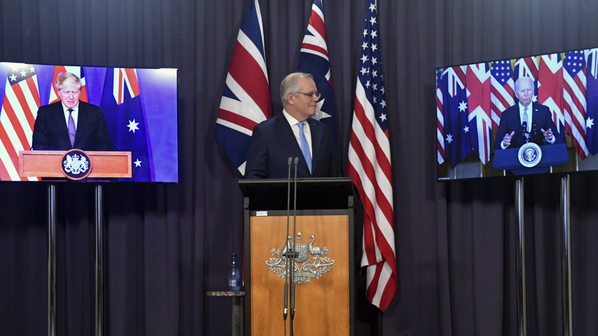 Der australische Premier Morrison mit Großbritanniens Premier Johnson und dem US-Präsidenten Biden zugeschaltet. | AP