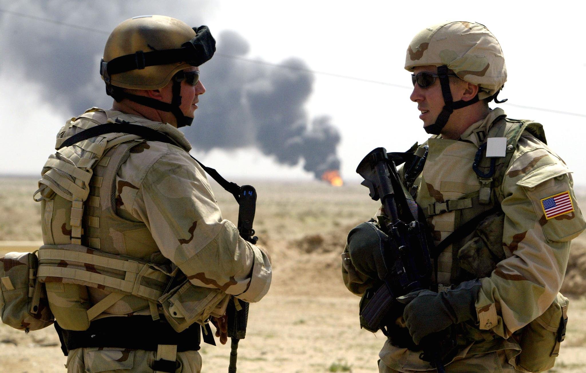 US-Soldaten stehen im März 2003 in der Nähe des brennenden Ölfelds Rumaila (Irak) | picture-alliance / dpa