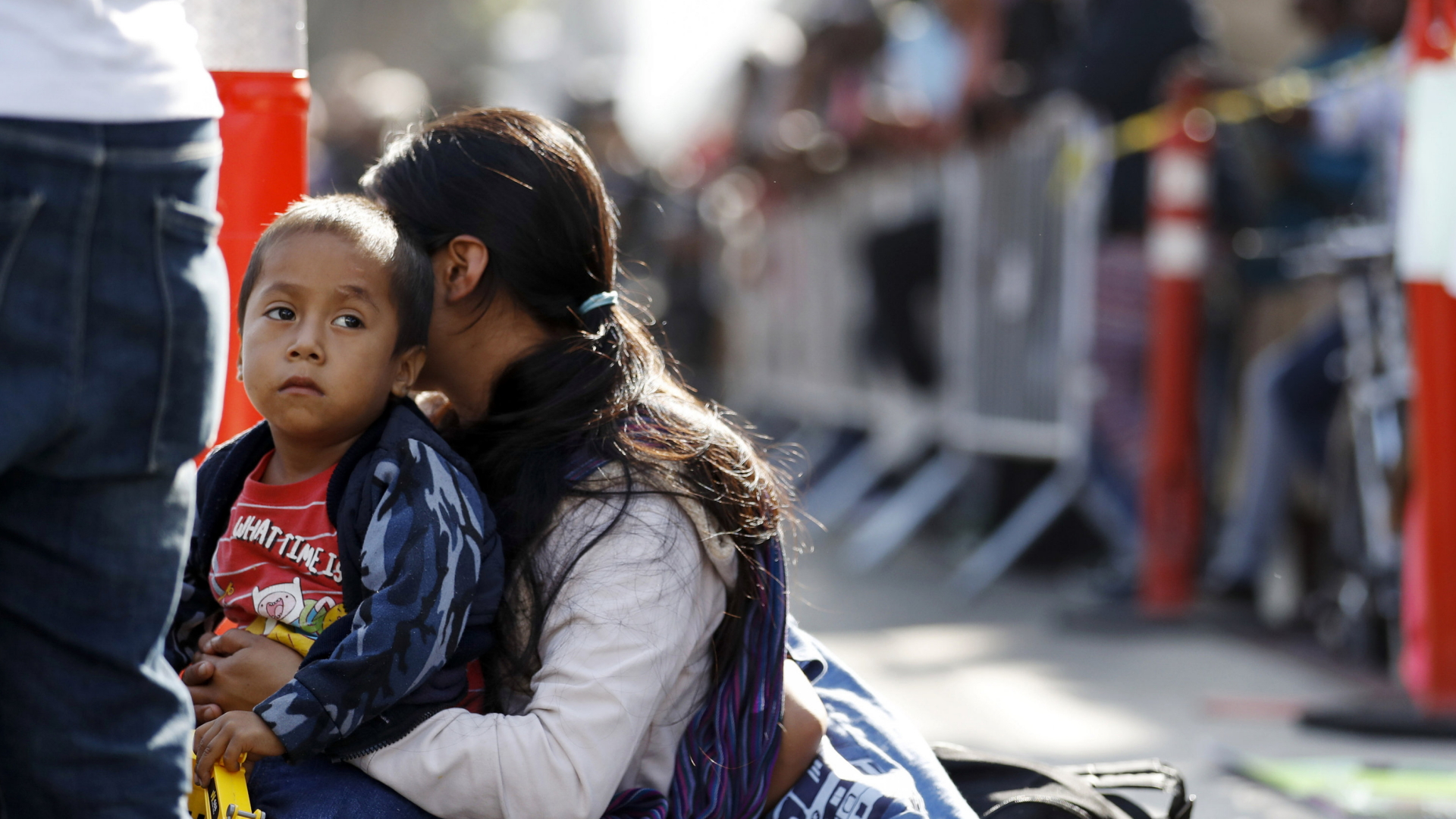 Eine Frau wartet mit ihren Söhnen an der mexikanischen Grenze auf die Antragstellung eines Asylantrags in den Vereinigten Staaten.