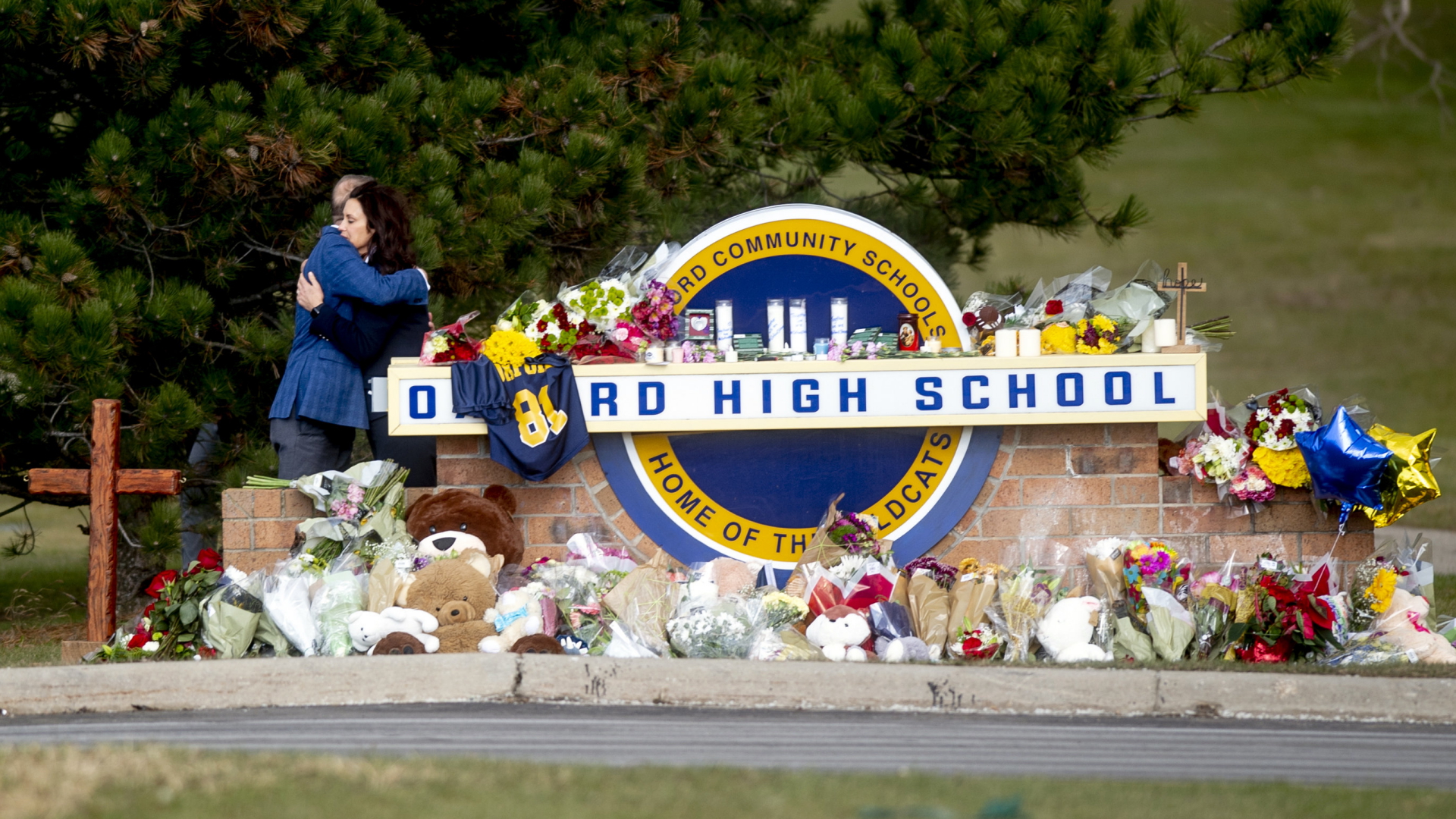 Nach einem tödlichen Schussangriff im Dezember 2021 liegen um das Eingangsschild der Highschool Blumen und Kuscheltiere zum Zeichen der Trauer. | AP