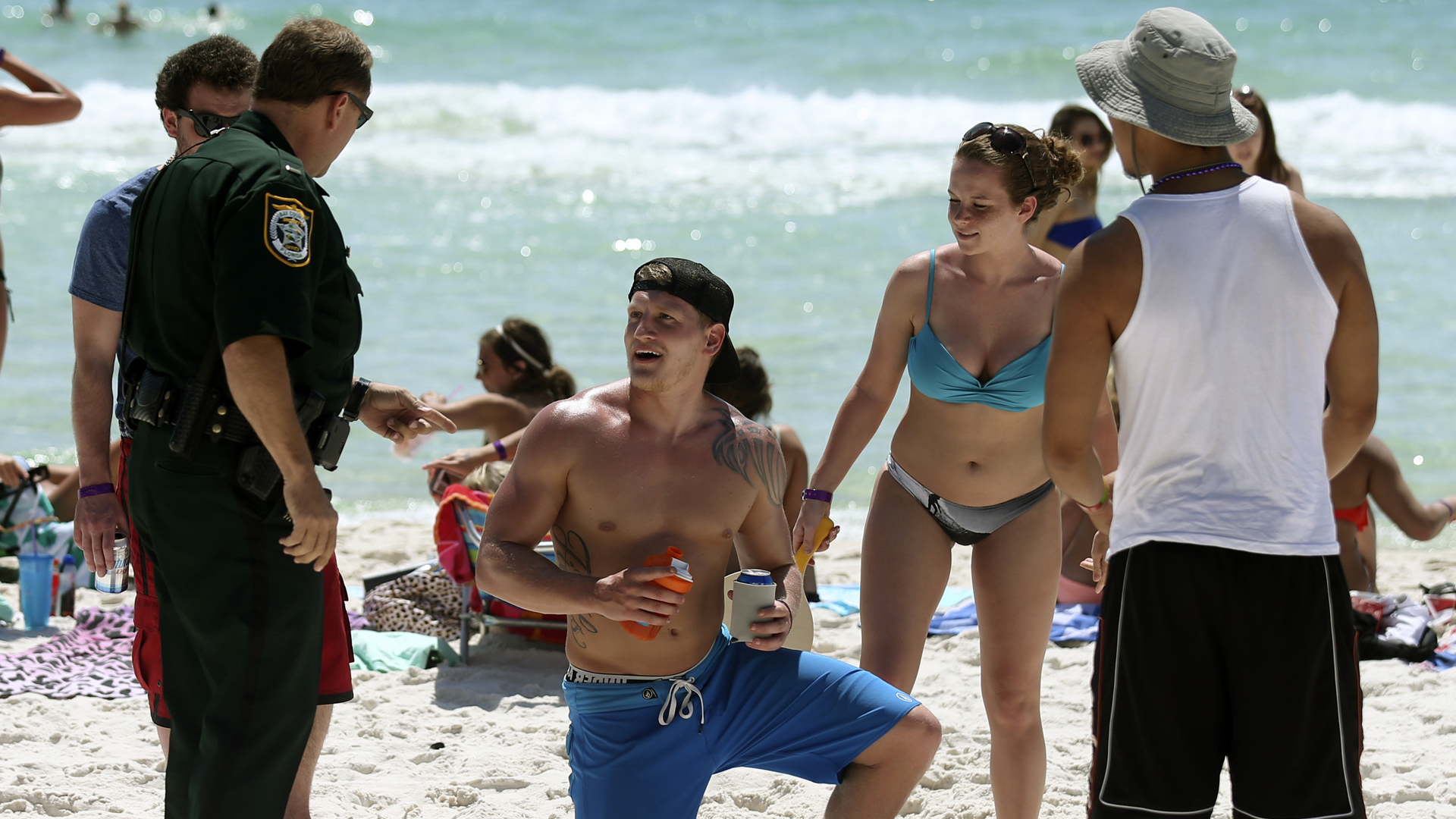 Ein Polizist weist junge Spring Break-Urlauber darauf hin, dass am Panama City Beach in Florida ein Alkoholverbot gilt. | picture alliance / AP Images