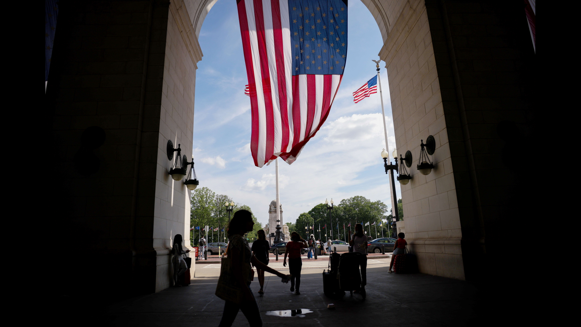 Reisende gehen am Bahnhof Union Station in Washington D.C. unter einer US-amerikanischen Flagge hindurch. | AFP