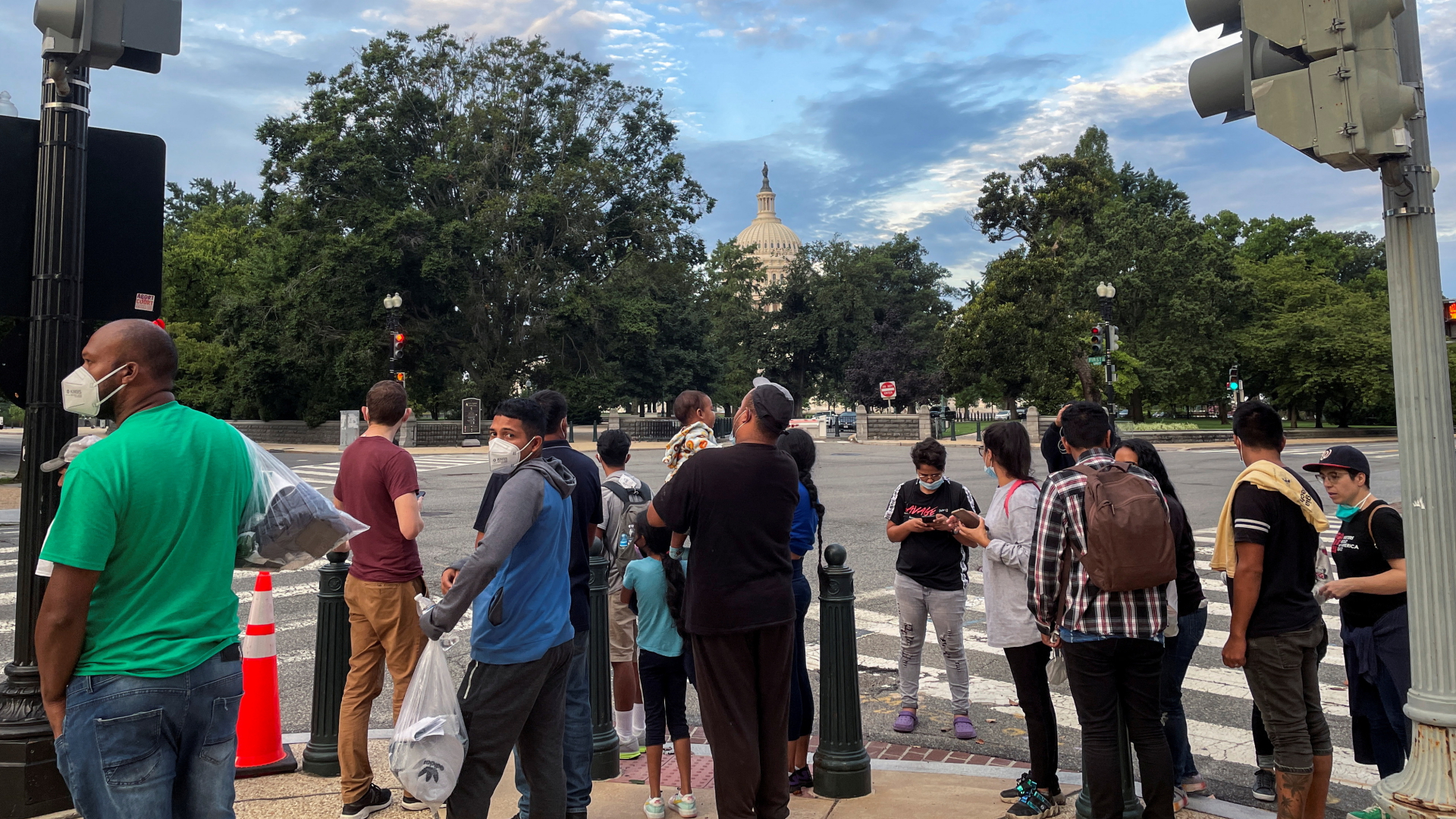 Migranten aus Mittel- und Südamerika stehen nach ihrer Ankunft in Washington D.C (USA)  auf einer Straße mit Blick auf das Capitol. | REUTERS
