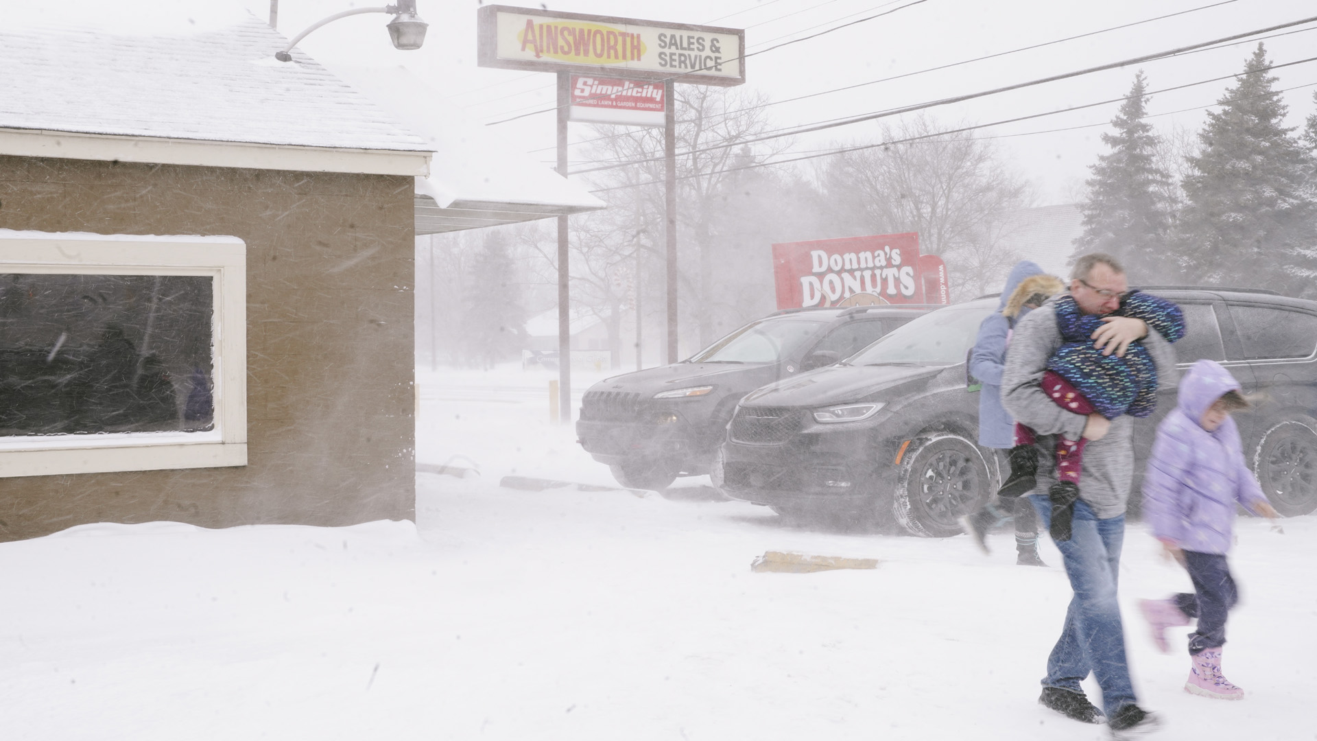 Eine Familie läuft über einen verschneiten Parkplatz in Flint, Michigan.