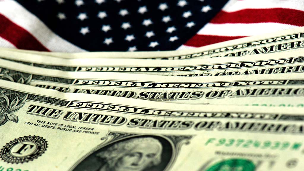 Dollarnoten vor einer US-Fahne | dpa