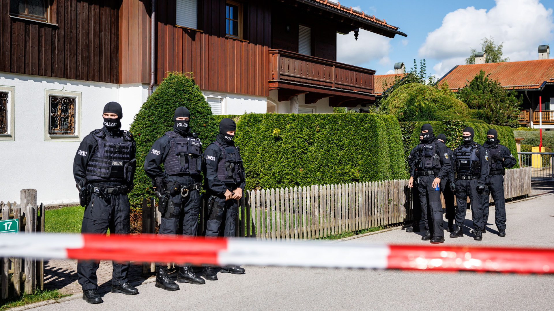 Maskierte Polizisten stehen bei einer Razzia vor einem Haus des russischen Oligarchen Usmanow | dpa