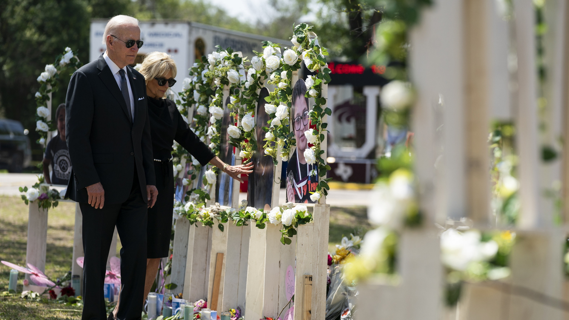 US-Präsident Biden und seine Frau Jill stehen vor weißen Holzkreuzen, die an die Opfer des Schulmassakers von Uvalde erinnern. | AP
