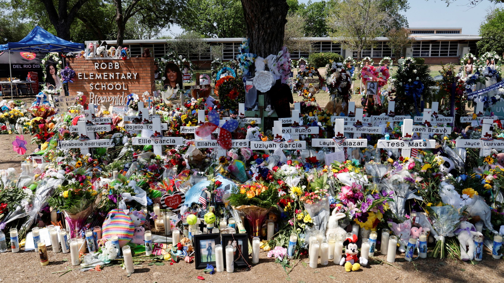 Weiße Holzkreuze vor denen Blumen niedergelegt wurden erinnern an die Toten des Schulmassakers von Uvalde. | REUTERS