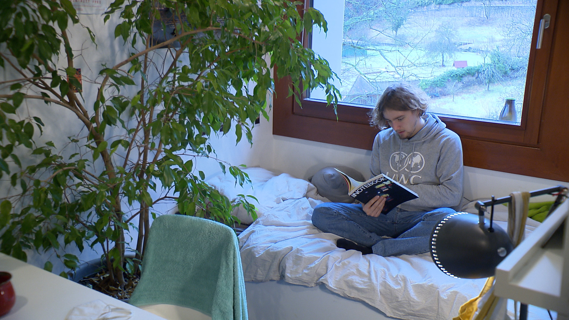Der UWC-Schüler Heinrich sitzt auf seinem Bett und liest. | Jenni Rieger, SWR