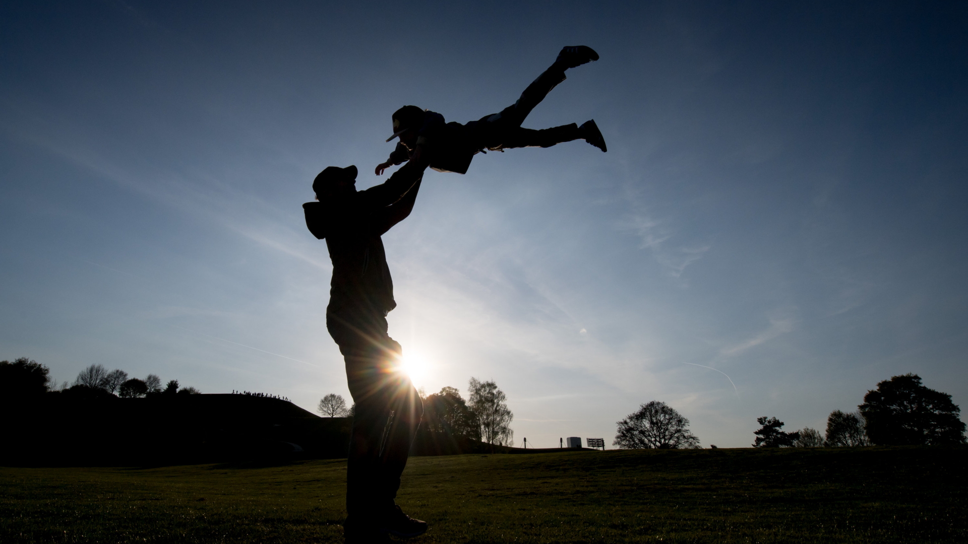 Ein Vater wirbelt sein Kind in die Luft.  | dpa