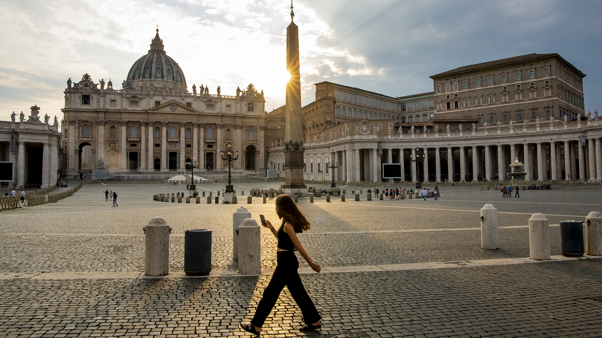 Eine Frau spaziert auf dem Petersplatz in der Vatikanstadt. | dpa