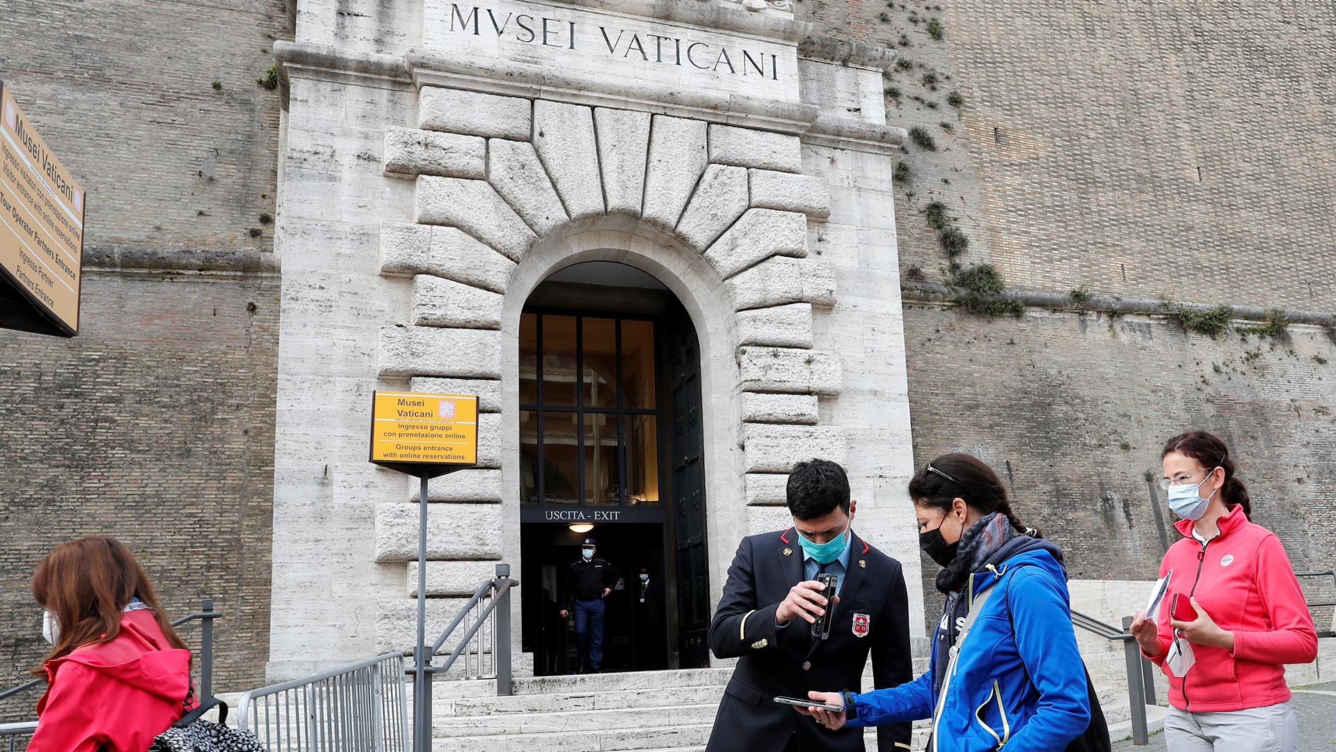 Menschen warten in einer Schlange vor dem Eingang der Vatikanischen Museen.