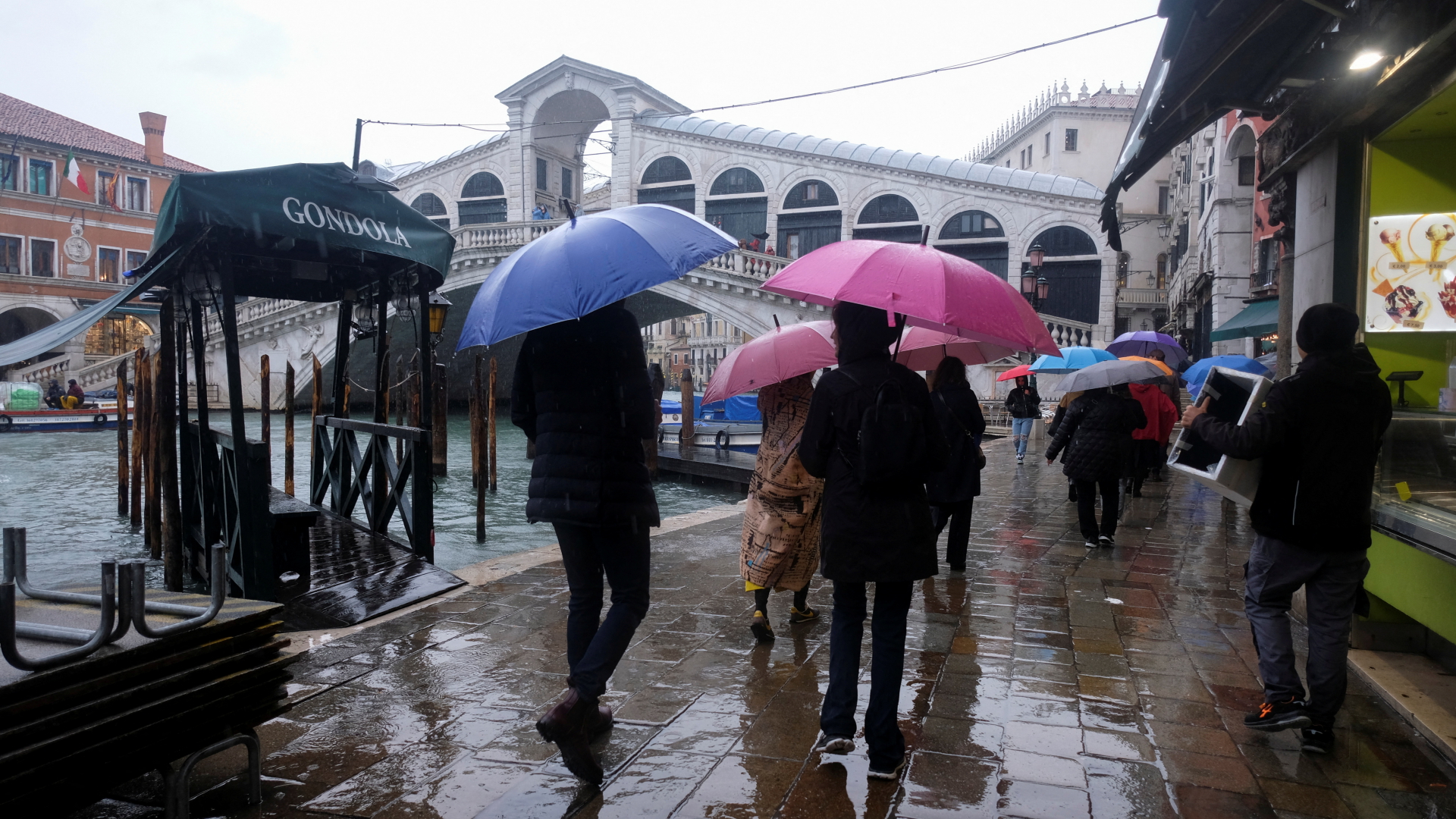 Menschen laufen nahe der Rialtobrücke in Venedig während des Hochwassers. | REUTERS