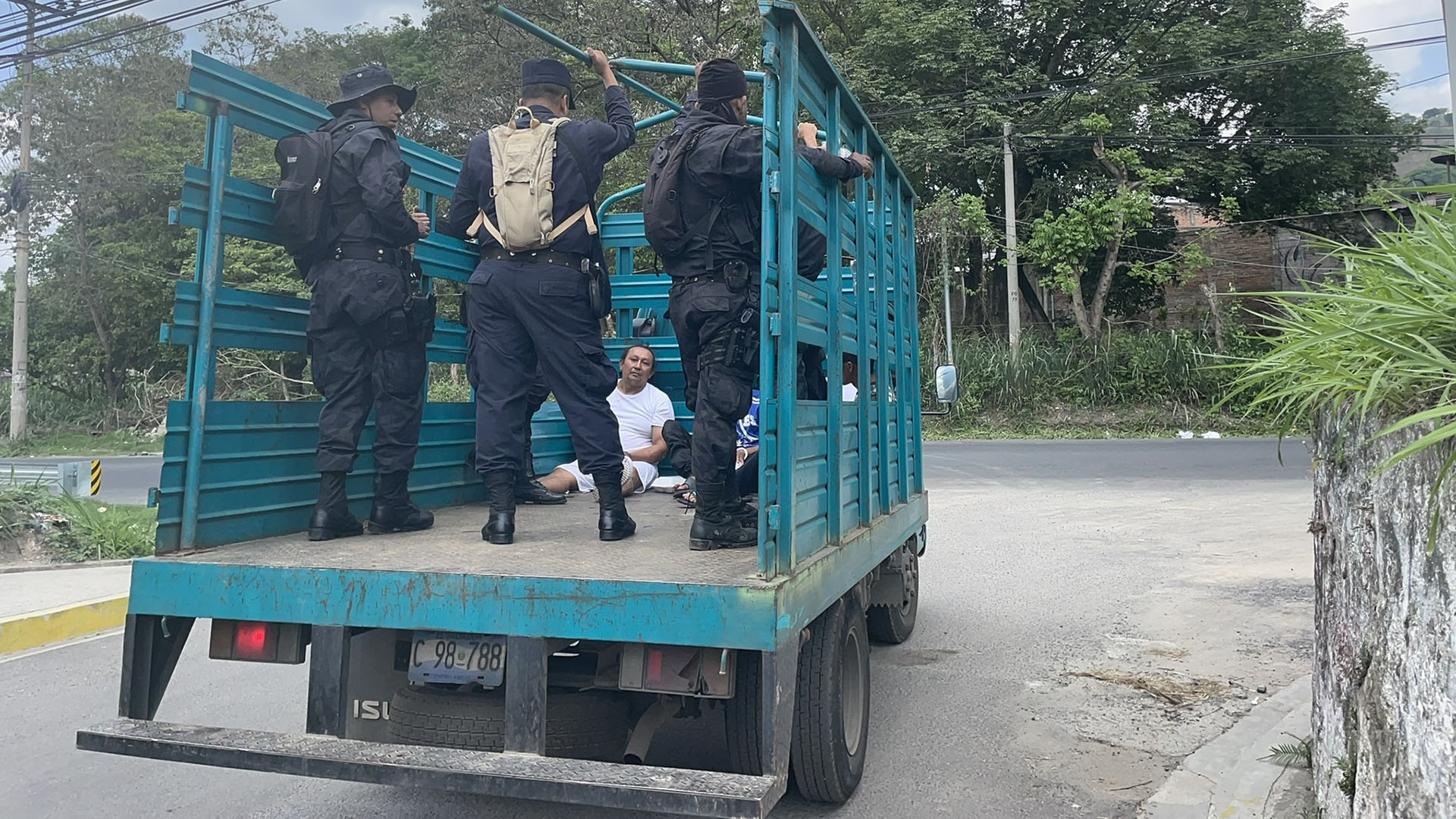 Verhaftete sitzen in El Salvador auf einem Lkw und werden von Polizisten bewacht. | Anne Demmer