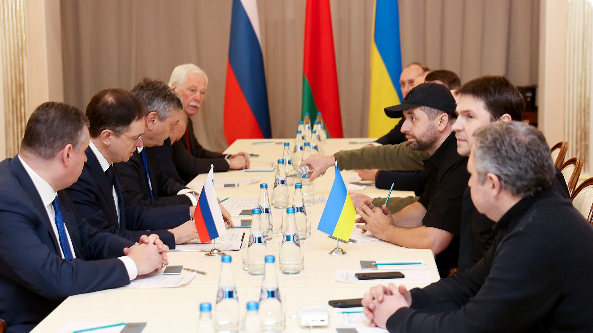 Die Delegationen aus Russland und der Ukraine sitzen an einem Tisch, um zu verhandeln. 