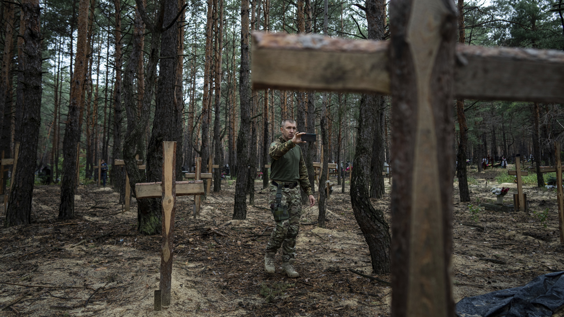 Vermisstenbeauftragter Oleh Kotenko macht Fotos der Gräber | dpa