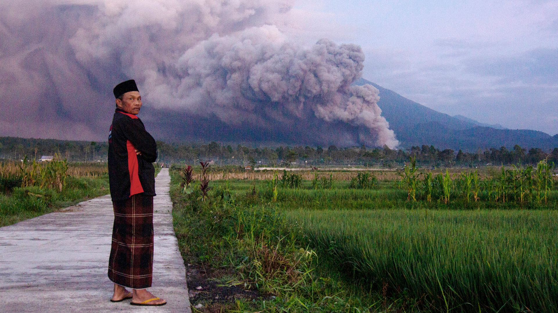 Ein Mann beobachtet den Ausbruch des Vulkans Semeru. | picture alliance/dpa/AP