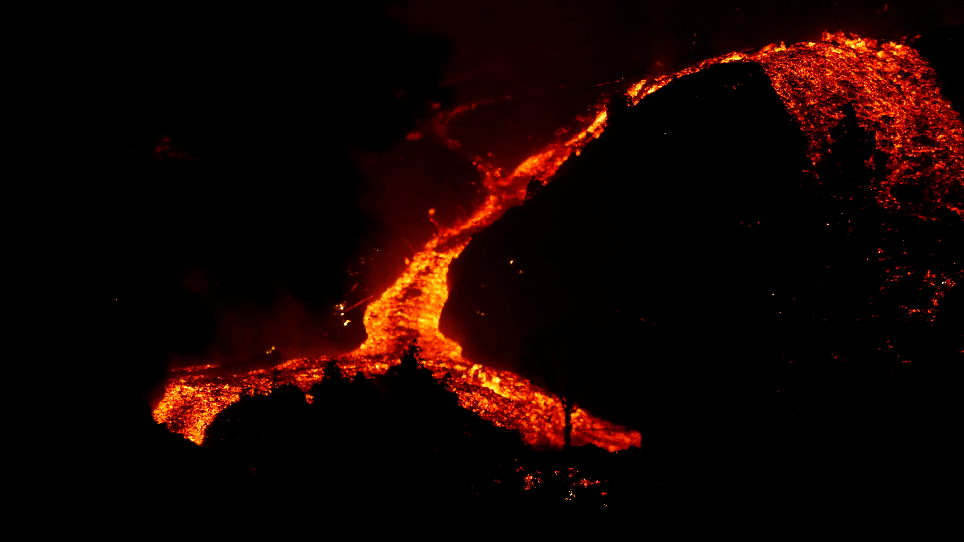 Lava aus dem Vulkan Cumbre Vieja auf La Palma schiebt sich einen Berg hinunter. | REUTERS