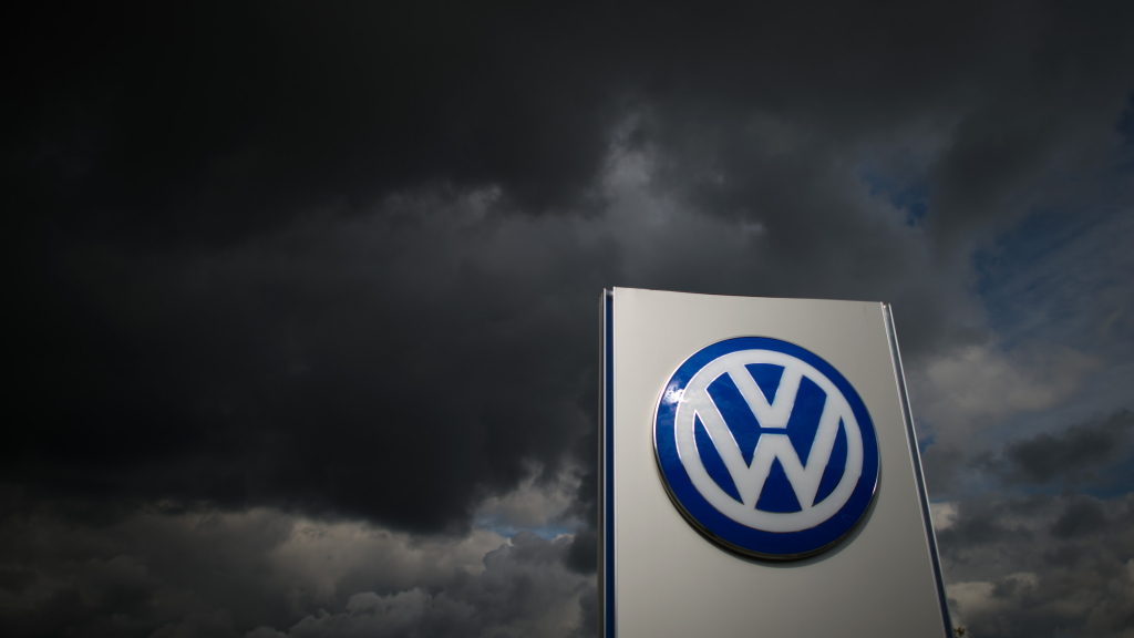 VW-Emblem, große schwarze Wolken: Der Absatz beim Konzern bricht ein | dpa