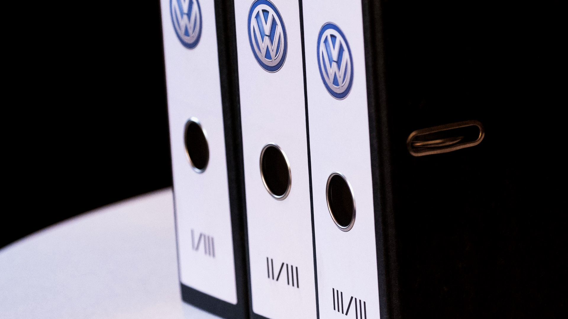 Akten zu einer Klage gegen den VW-Konzern während einer Pressekonferenz auf einem Tisch | dpa