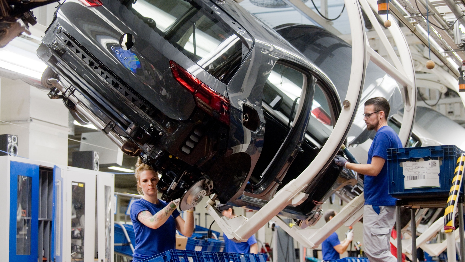 Zwei Mitarbeiter arbeiten an einem Volkswagen Golf 8 a im VW-Werk in Wolfsburg. | dpa
