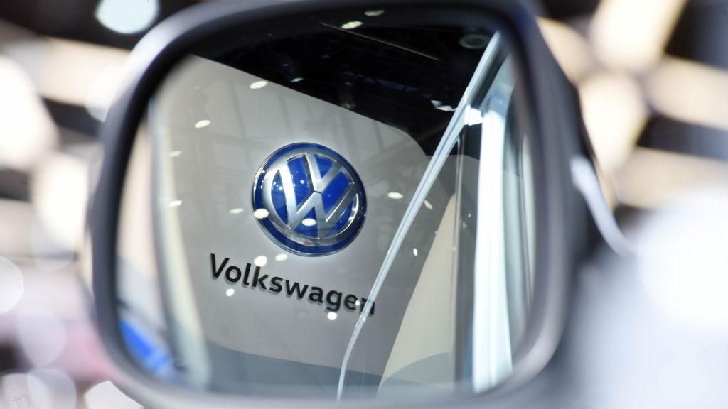 Das VW-Logo spiegelt sich im Seitenspiegel eines Austellungswagens auf dem Genfer Autosalon