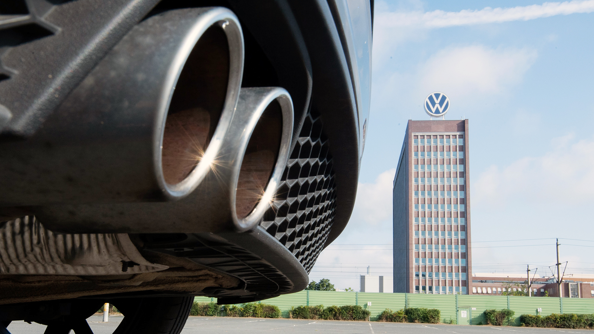 Auspuffrohre eines Volkswagen, fotografiert mit dem Markenhochhaus am VW Werk Wolfsburg | dpa