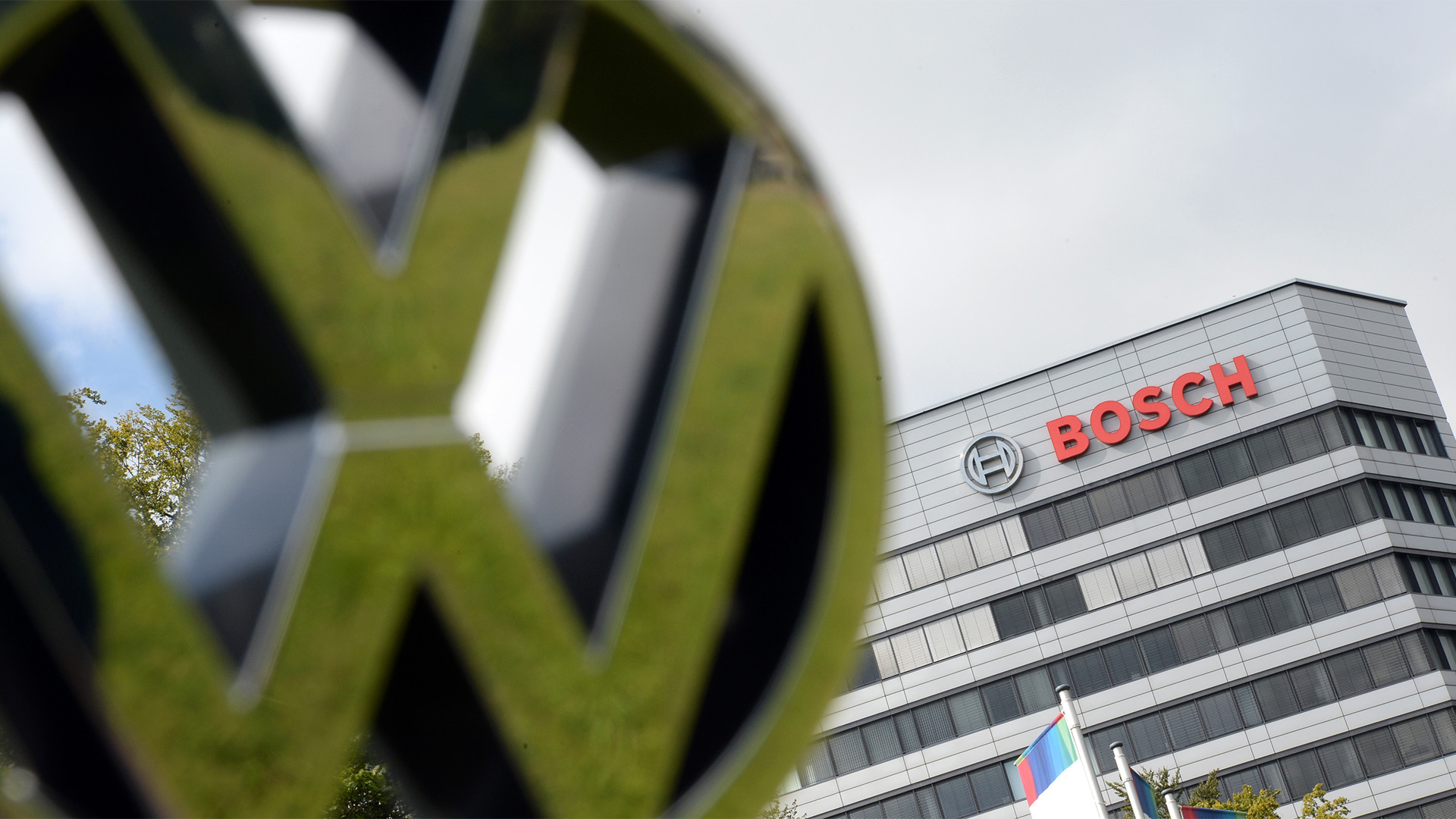 Ein VW Logo wird in Gerlingen (Baden-Württemberg) vor den Bosch Stammsitz gehalten. | picture alliance / dpa