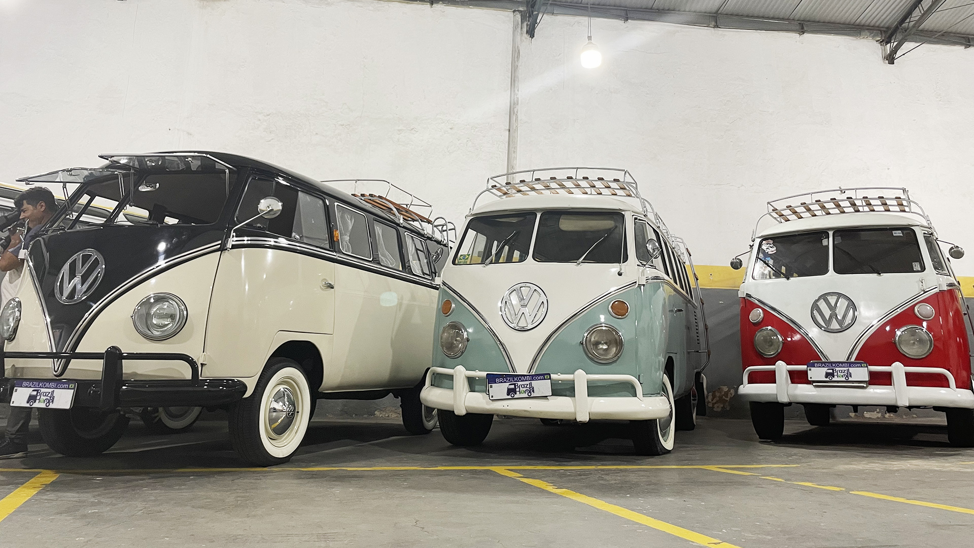 Alte restaurierte VW-Busse stehen in einer Halle.
