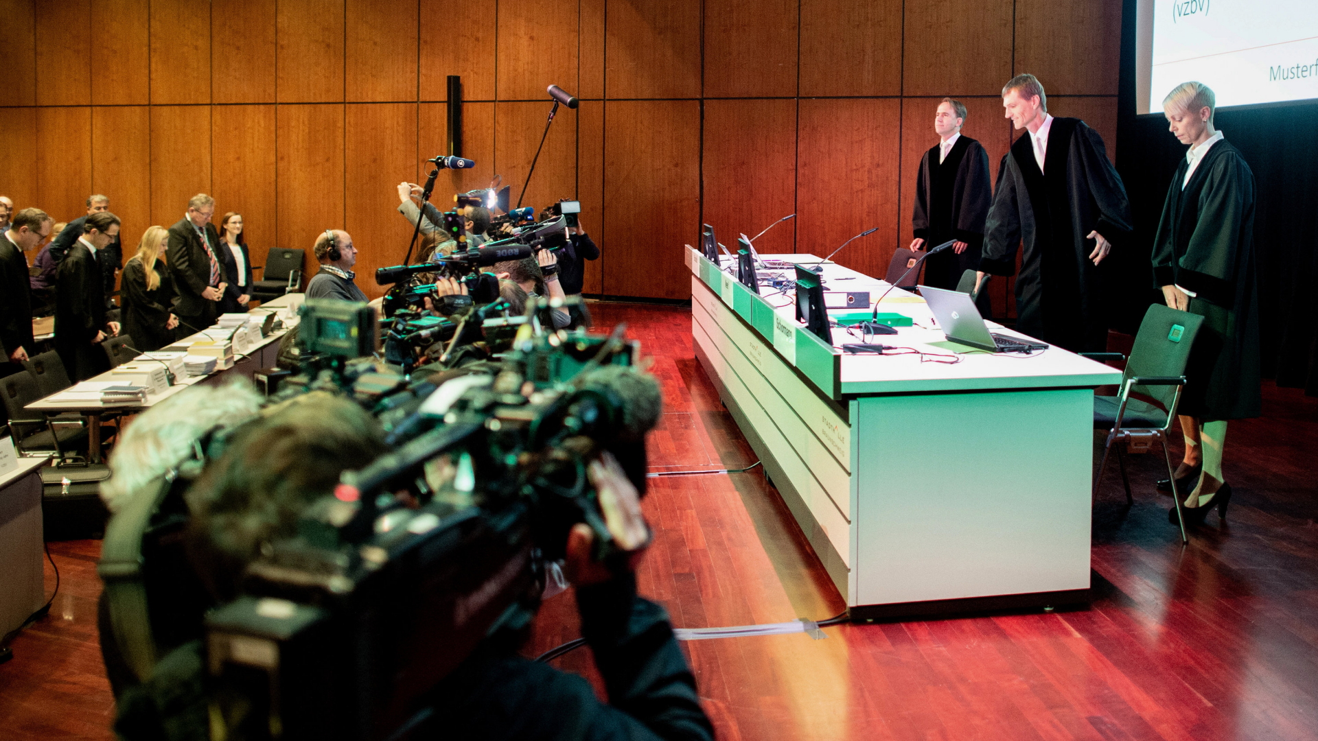 Drei Richter am Oberlandesgericht Braunschweig stehen vor Beginn der mündlichen Verhandlung zur Musterfeststellungsklage des Bundesverbands der Verbraucherzentralen und Verbraucherverbände gegen VW in der Stadthalle. | dpa