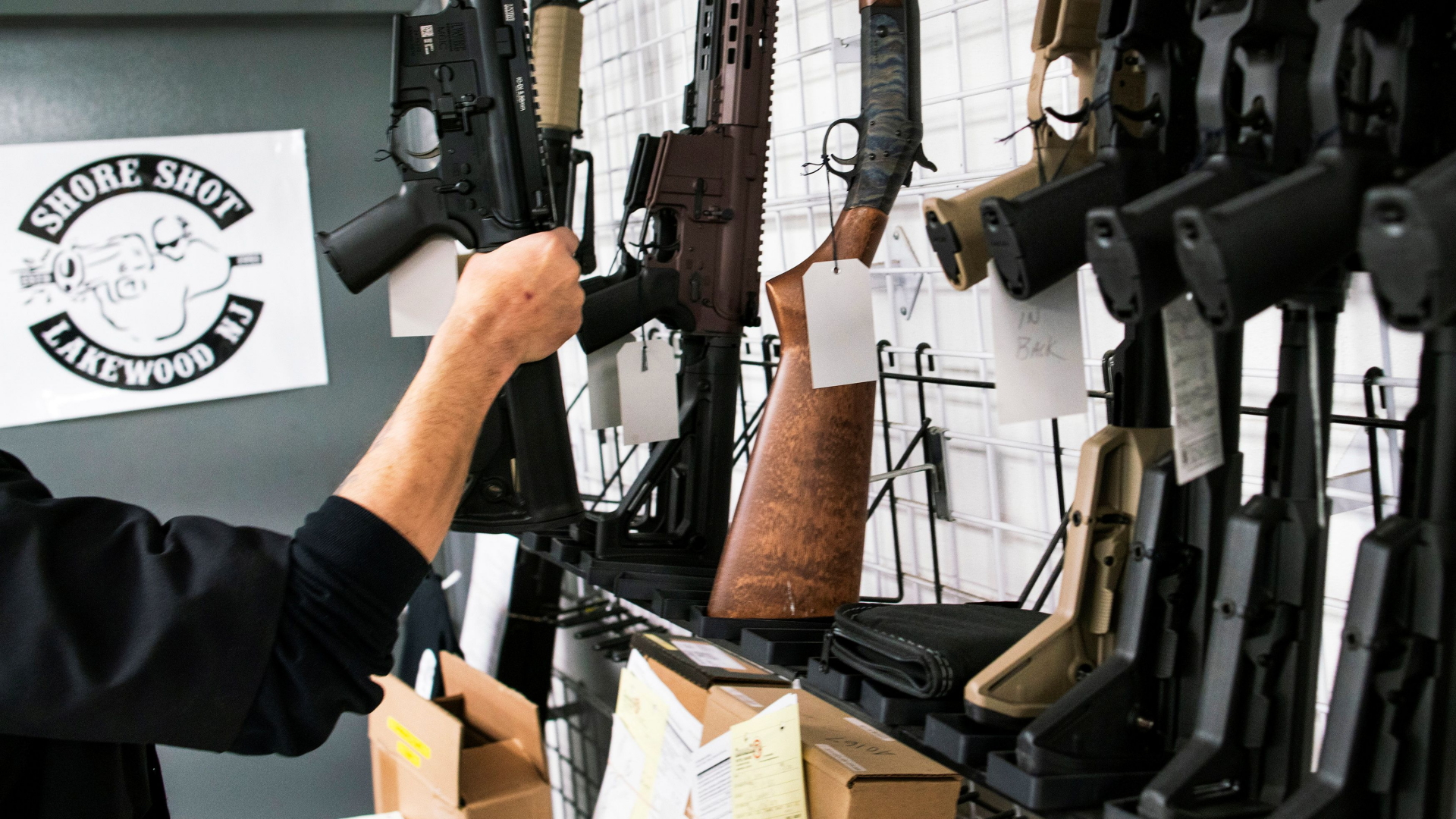 Ein Mann greift nach einer Waffe in einem Waffenladen in den USA. | REUTERS