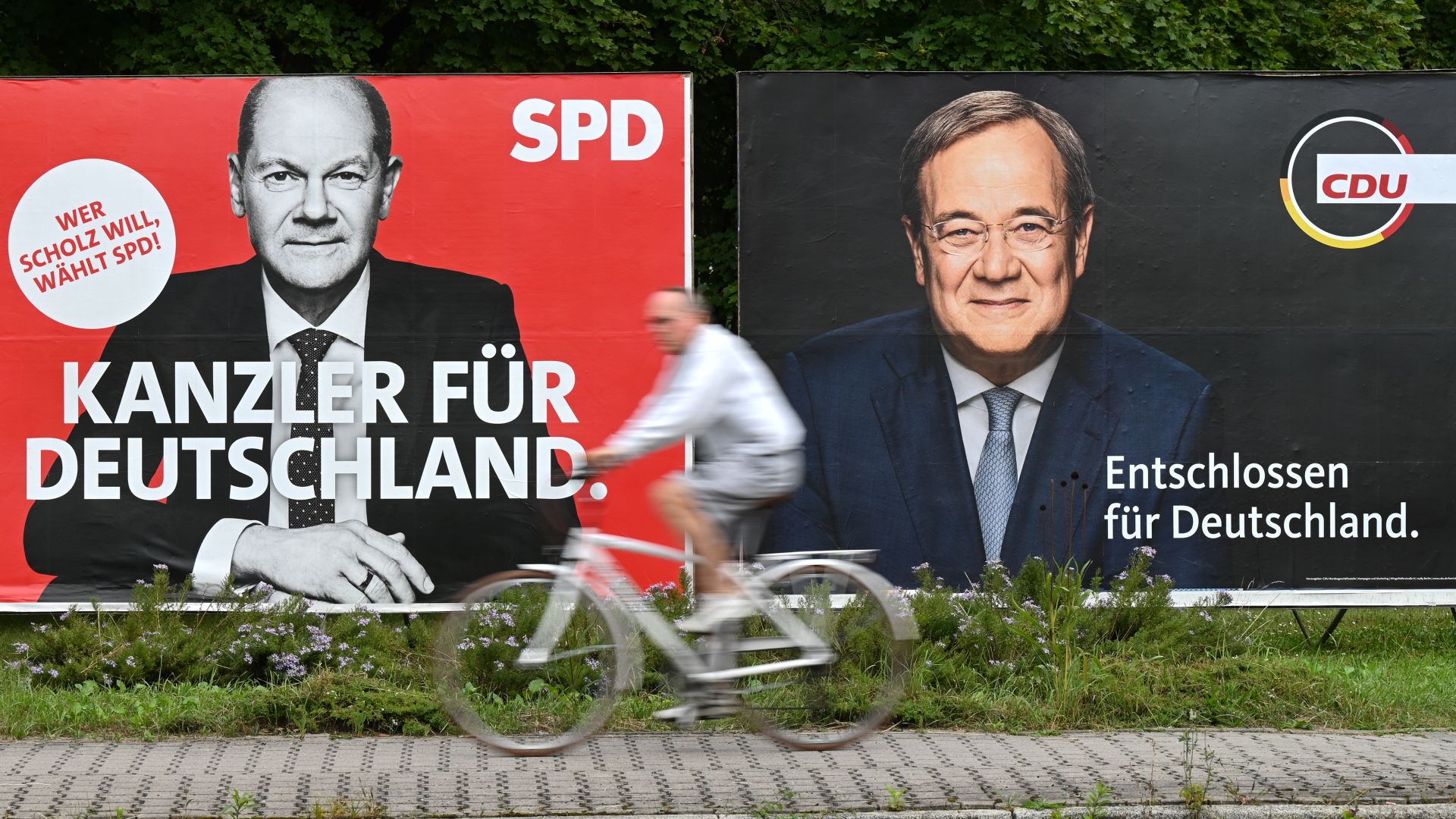  Ein Radfahrer fährt Wahlplakaten mit den Spitzenkandidaten Olaf Scholz (SPD) und Armin Laschet (CDU) vorbei.