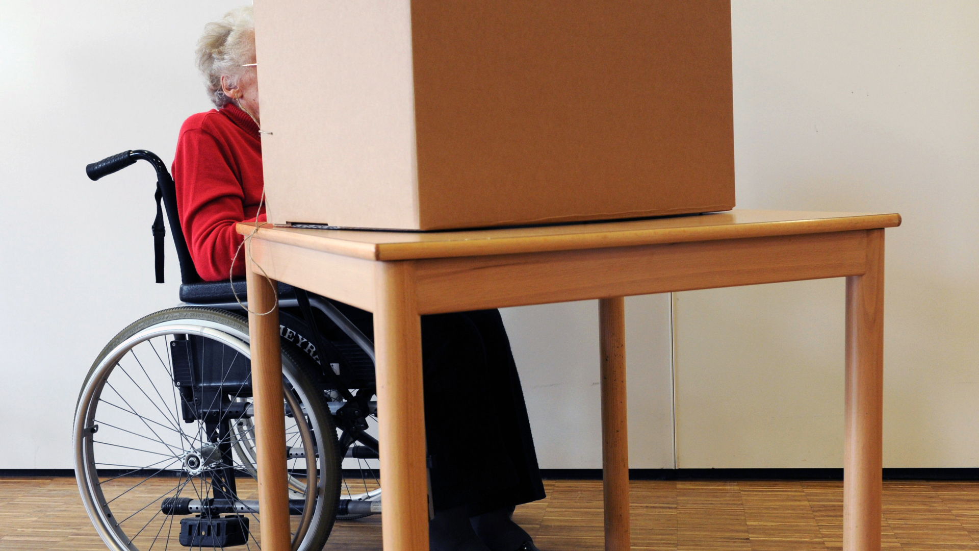 Eine Wählerin im Rollstuhl gibt in einem Wahllokal ihre Stimme für die Bürgerschaftswahl in Hamburg ab. | dpa