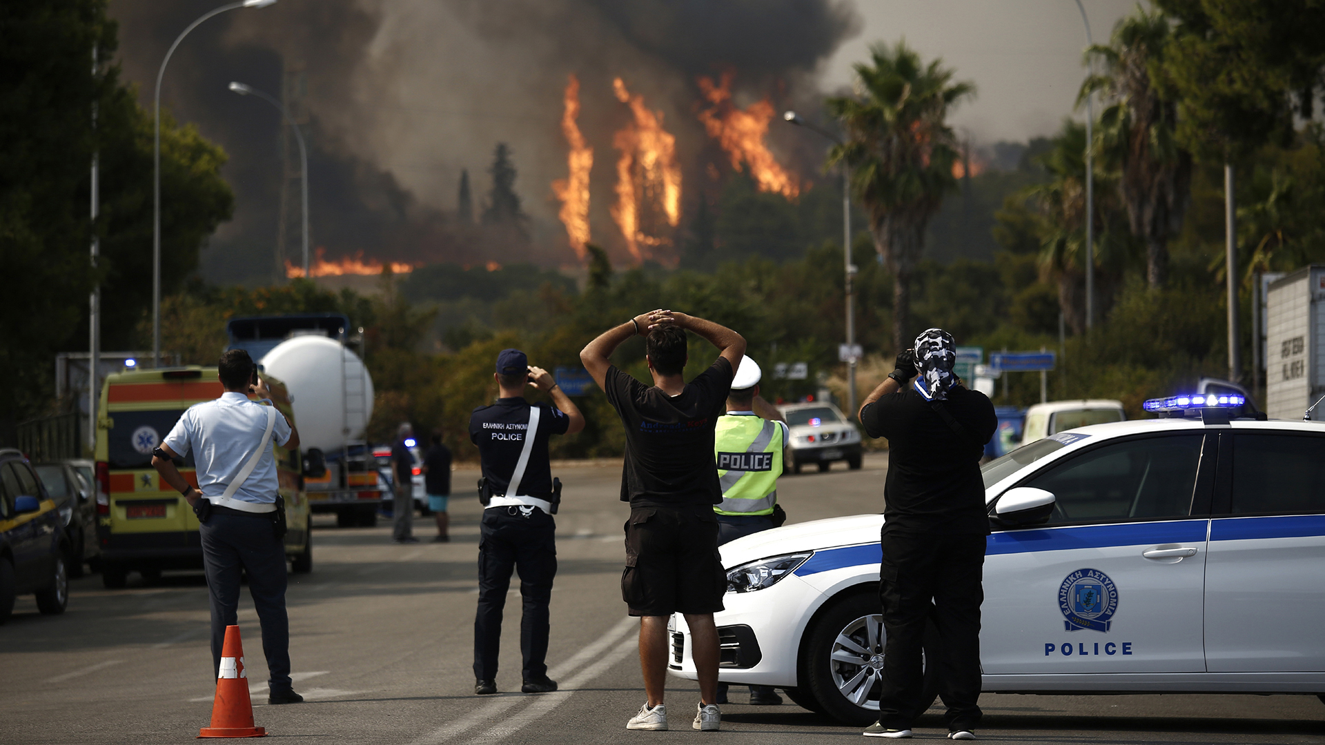 Anwohner und Polizisten blicken auf einen Waldbrand bei Varympompi. | EPA