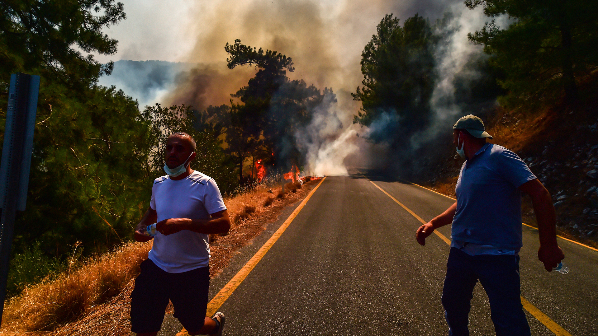 Menschen laufen vor einem Waldbrand in Bodrum weg. | AP