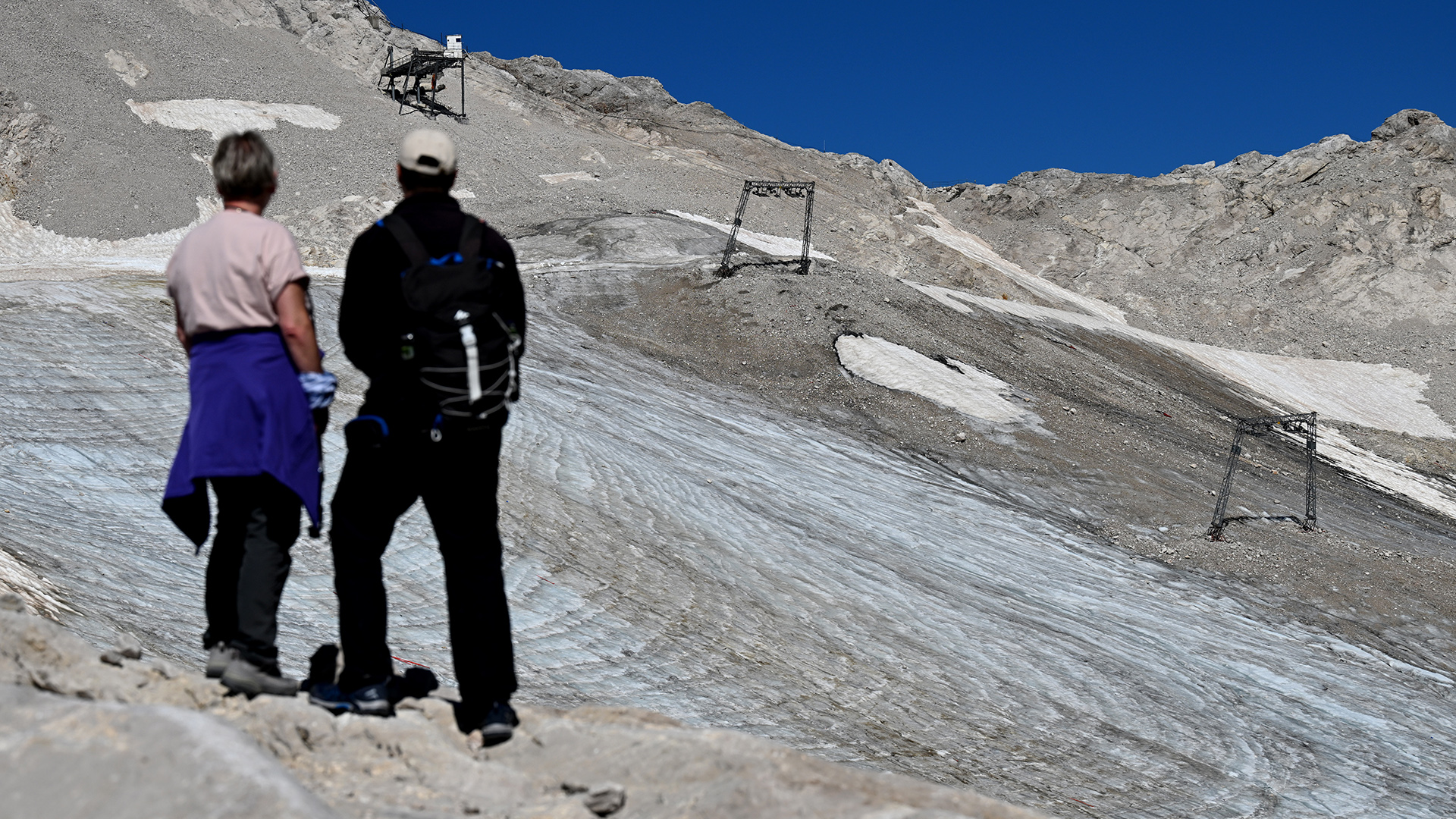 Wanderer betrachten auf dem Zugspitzplatt die Reste des Nördlichen Schneeferner Gletschers. | dpa