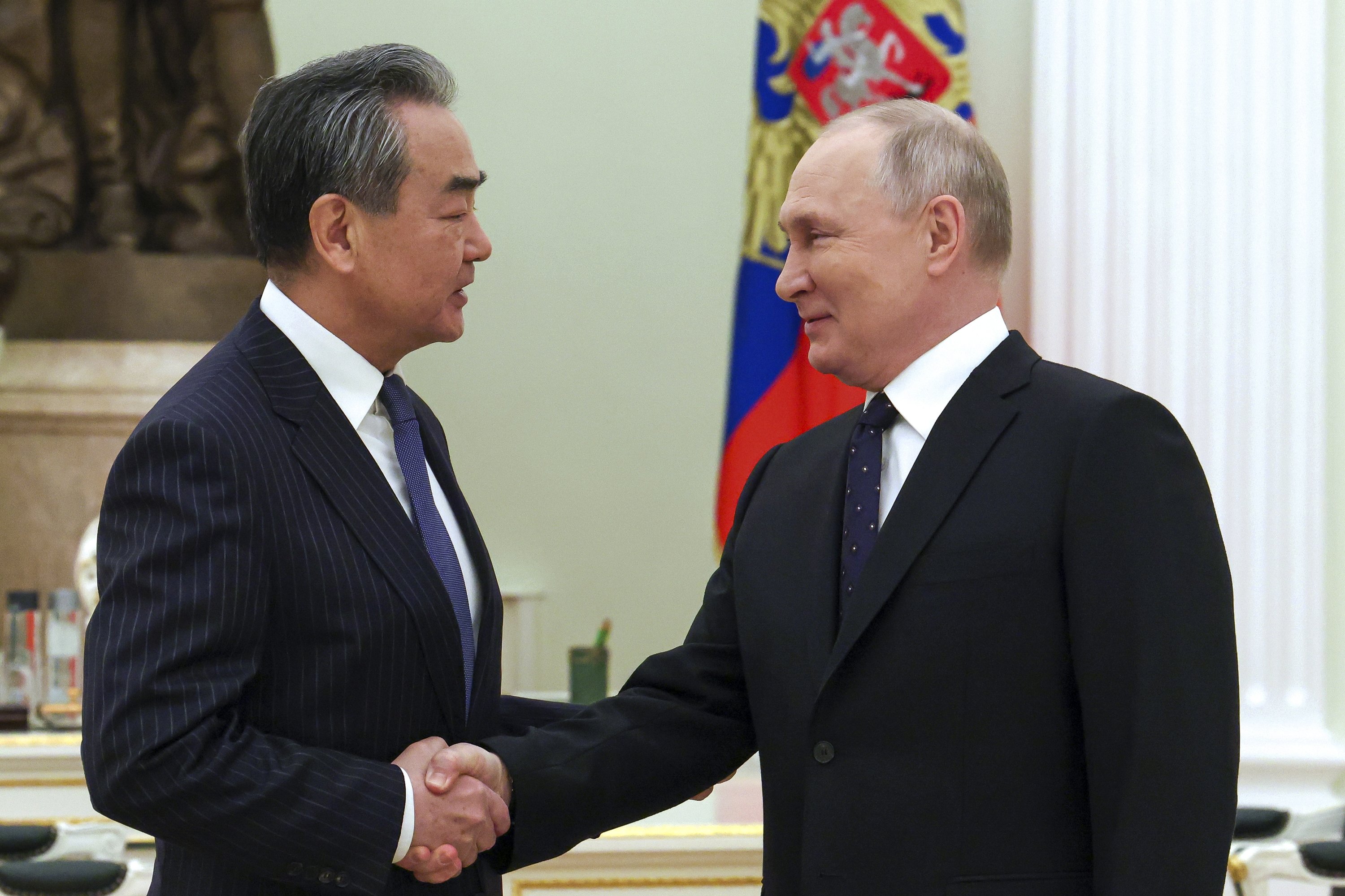 Wang Yi (links) und Wladimir Putin schütteln sich im Kreml die Hand | AP