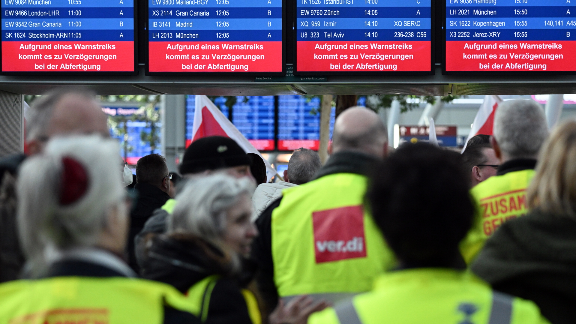 Streikende Flughafen-Mitarbeiter stehen mit Verdi-Flaggen im Terminal des Flughafens Düsseldorf. (Archivbild vom 27. Februar 2023) | dpa