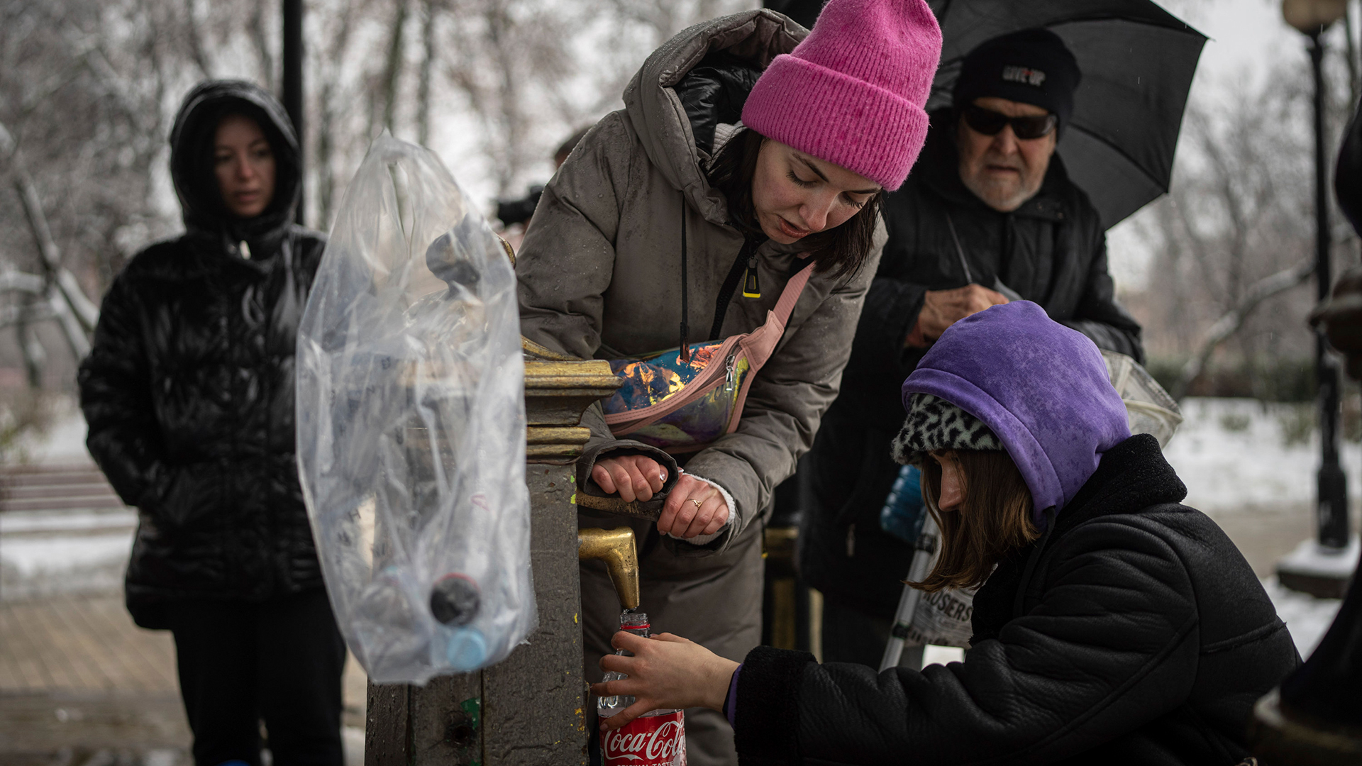 Anwohner von Kiew füllen sich Wasser in Flaschen ab. | AP
